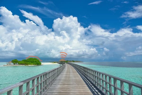Pasarela de madera hacia una isla tropical que representa el inicio de un primer viaje en solitario.